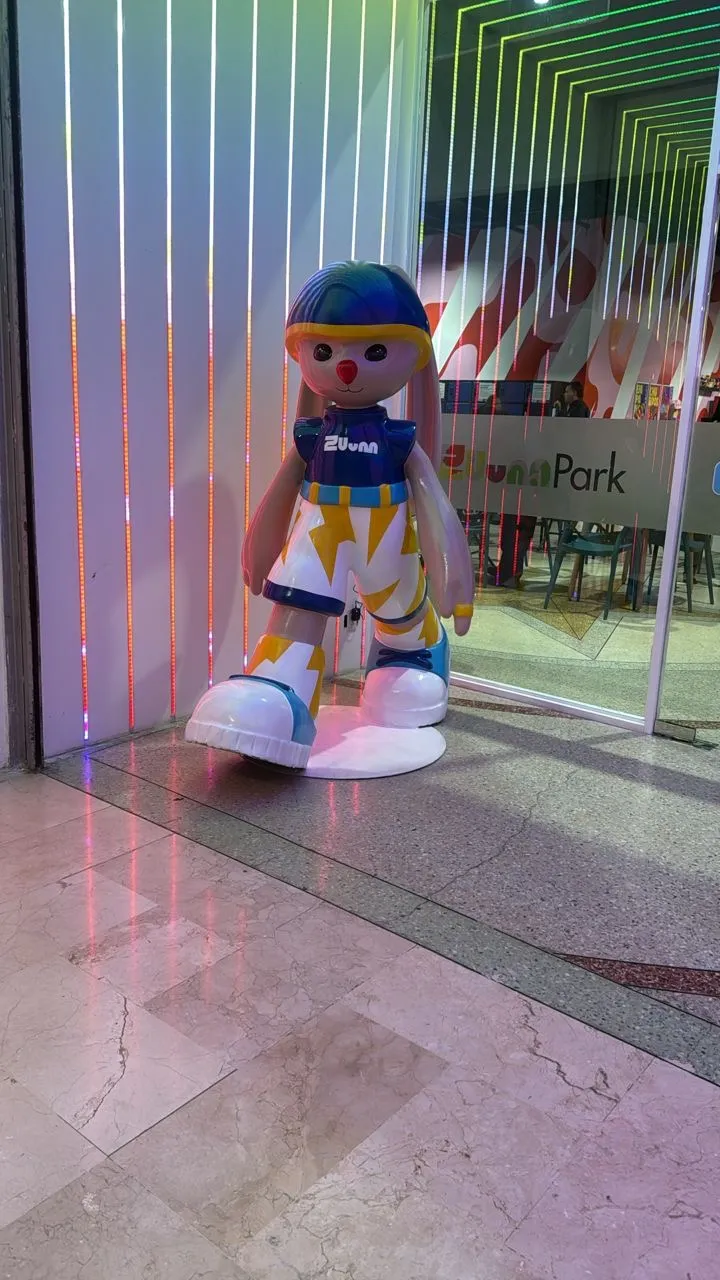 Figura decorativa de mascota Zuum Park en la entrada del parque con iluminación de colores