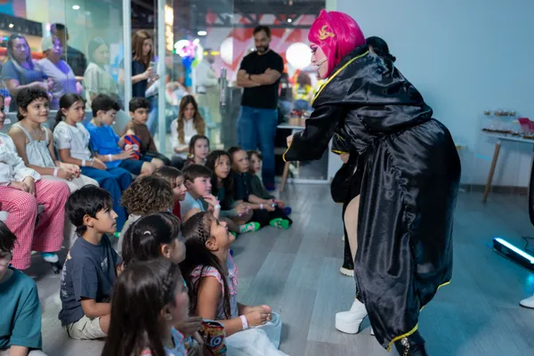 Animadora con peluca rosada interactuando con niños durante una celebración de cumpleaños en Zuum Park