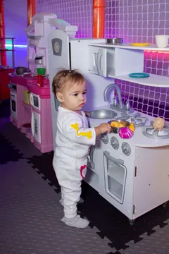 Bebé explorando la cocina de juguete en el área Chiqui Mundo de Zuum Park